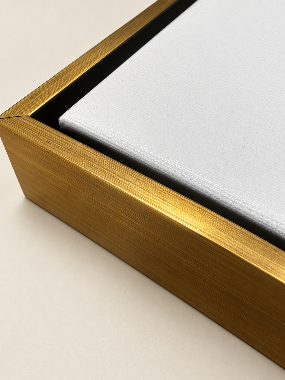 Close-up of a brushed gold floating frame with a black gap around the canvas.